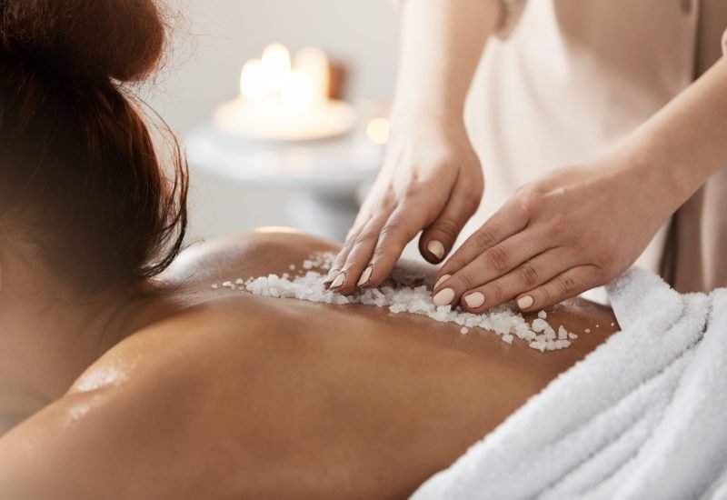 Close up of african girl relaxing enjoying spa health massage with sea salt. Close up photo of young beautiful african girl relaxing enjoying spa health massage with sea salt.